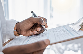 Person holding clipboard while filling out form