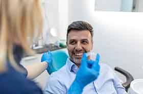 Smiling man attending Invisalign check-in appointment