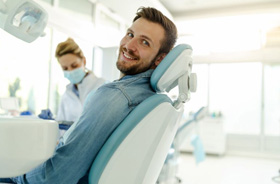 Happy dental patient looking over his shoulder