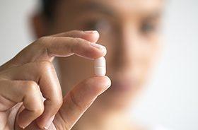Patient holding white sedative pill