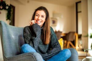 Smiling woman sitting in her armchair at home