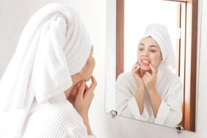 Woman looking at her teeth in bathroom mirror